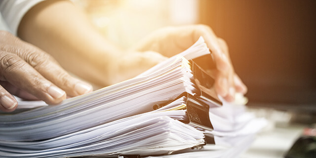 Person looking over a pile of sorted documents
